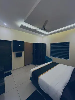 a bedroom with a bed and a ceiling fan at Azay Luxurious Apartment in Kalpetta
