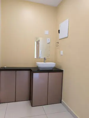 a bathroom with a sink and a mirror at Azay Luxurious Apartment in Kalpetta