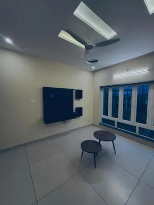 a room with two tables and a flat screen tv at Azay Luxurious Apartment in Kalpetta