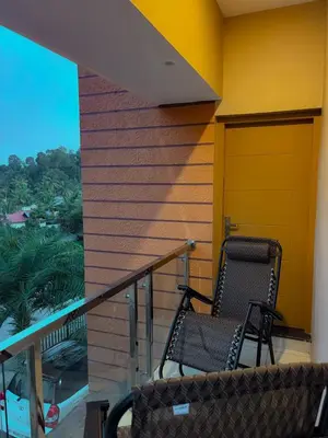 two chairs sitting on the balcony of a house at Azay Luxurious Apartment in Kalpetta