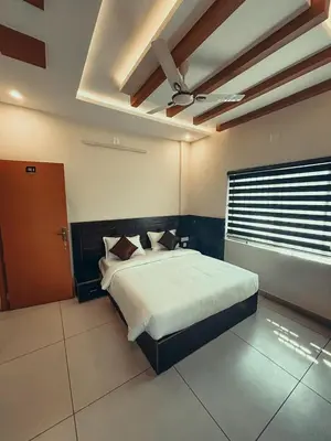 a bedroom with a bed and a ceiling fan at Azay Luxurious Apartment in Kalpetta