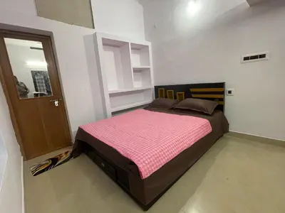 a bedroom with a large bed with a pink blanket at Rock Hill - Pachakkad Home Stay in Athirappally