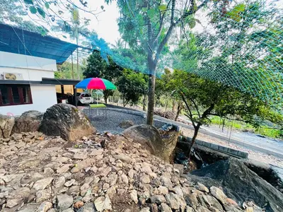 a colorful umbrella sitting on top of a pile of rocks at Rock Hill - Pachakkad Home Stay in Athirappally