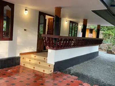 a house with a staircase leading to the front door at Rock Hill - Pachakkad Home Stay in Athirappally