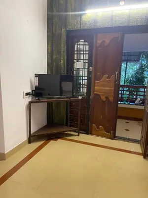 a living room with a door and a tv and a door at Rock Hill - Pachakkad Home Stay in Athirappally