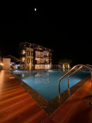 a swimming pool in front of a building at night at Crystal Winter Arcade wayanad in Wayanad