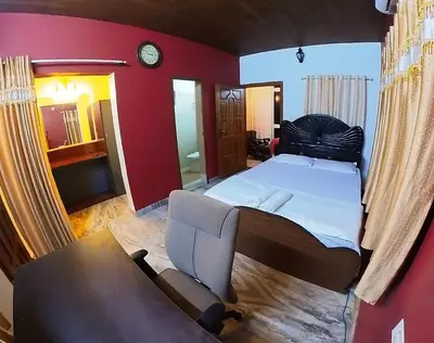 a bedroom with a bed and a couch and a chair at Entire Villa Homestay Rooms IRITTY in Irrity