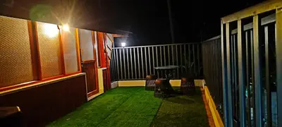 a balcony with chairs and a table at night at Entire Villa Homestay Rooms IRITTY in Irrity