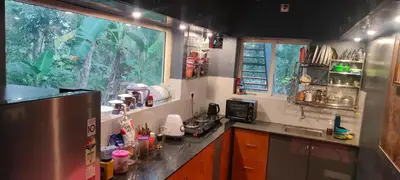 a kitchen with a sink and a refrigerator and a window at Entire Villa Homestay Rooms IRITTY in Irrity