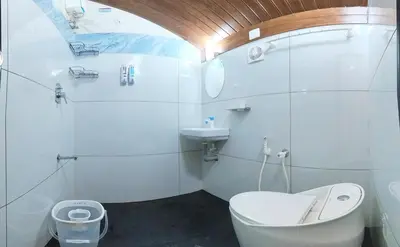 a white bathroom with a toilet and a sink at Entire Villa Homestay Rooms IRITTY in Irrity