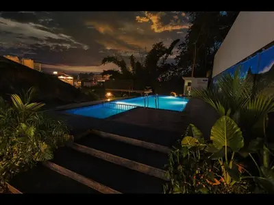 a swimming pool in the middle of a yard at Holidays Garden Resort in Kalpetta