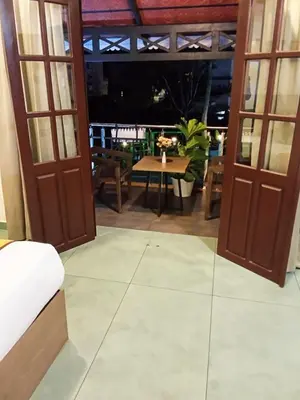 a room with two doors and a table and a table at Holidays Garden Resort in Kalpetta