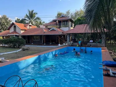 a group of people swimming in a swimming pool at Yes Yes Farms in Pollāchi