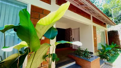 a house with green plants in front of it at Monarda Resort in Padinjarathara