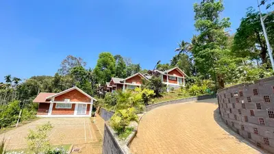 a row of houses on a hill next to a road at Monarda Resort in Padinjarathara
