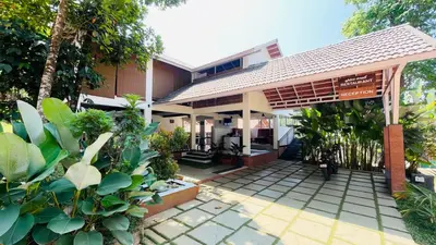 an entrance to a building with trees and plants at Monarda Resort in Padinjarathara
