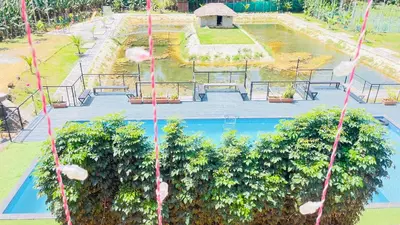 an overhead view of a pool with trees and pink strings at Monarda Resort in Padinjarathara