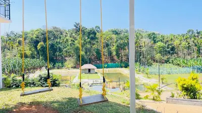 a view of a park with swings at Monarda Resort in Padinjarathara
