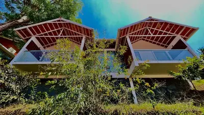 a house with two large windows on the side of it at Monarda Resort in Padinjarathara