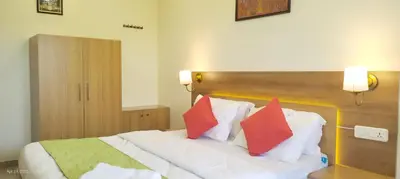 a bedroom with a white bed with red pillows at Sree Nandhanam apartment's in Guruvāyūr