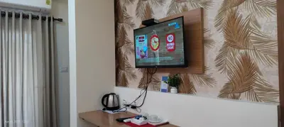 a flat screen tv hanging on a wall in a room at Sree Nandhanam apartment's in Guruvāyūr