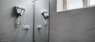 a bathroom with two phones on a wall at Sree Nandhanam apartment's in Guruvāyūr