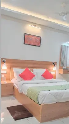 a bedroom with a large bed with red pillows at Sree Nandhanam apartment's in Guruvāyūr