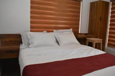 a bedroom with a large bed with a wooden headboard at Forest Brew Resort Wayanad in Chekadi