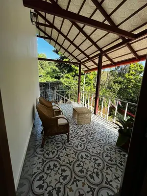 a patio with two chairs and a table on a floor at Birdsong Coffee Estate Stay in Madikeri