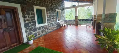a porch of a house with a stone wall at WellGrown- The Farmhouse at Kombai - Pallangi, Kodaikanal in Kodaikānāl