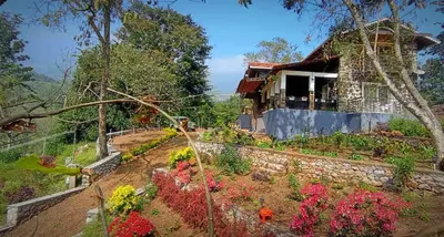 a house with flowers in front of it at WellGrown- The Farmhouse at Kombai - Pallangi, Kodaikanal in Kodaikānāl
