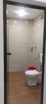 a bathroom with a toilet and a glass shower at VKJ Lodge in Alwaye