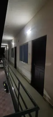 a hallway of a building with a door and a fence at VKJ Lodge in Alwaye