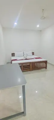 a room with two beds and a table at VKJ Lodge in Alwaye