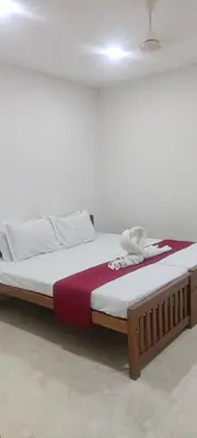 a large bed with a wooden frame in a room at VKJ Lodge in Alwaye