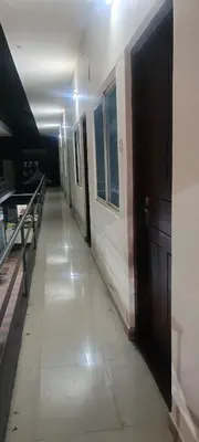 a hallway of a building with a door and benches at VKJ Lodge in Alwaye