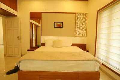 a bedroom with a large bed with a window at Welcome to SP Luxury Bed Villa in Kāladi