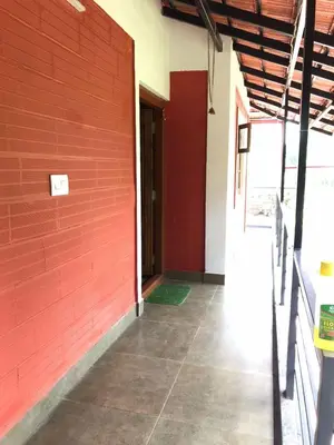 an empty room with a red brick wall at Snow Drop Villa in Gonikoppal