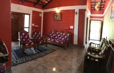 a room with chairs in a room with red walls at Snow Drop Villa in Gonikoppal
