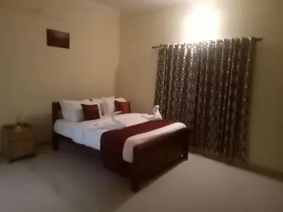 a small bedroom with two beds and a window at Airport villa in Chewarra
