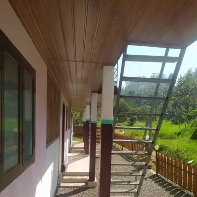 a hallway of a house with a wooden ceiling at haven bridge Homestay in Meenangadi