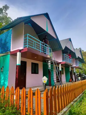 a house with a man standing on the balcony at haven bridge Homestay in Meenangadi