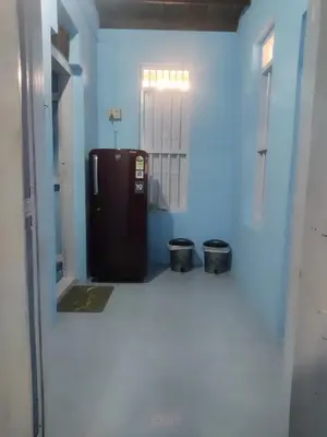 a refrigerator in a room with a blue wall at Arapura Veedu Heritage Homestay in Kizhillam