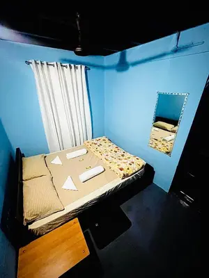 a blue room with a bed and a window at Arapura Veedu Heritage Homestay in Kizhillam