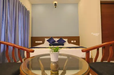 a room with a bed and a table with a glass table sidx sidx sidx at Tour Way Nadavayal Inn in Kenichira