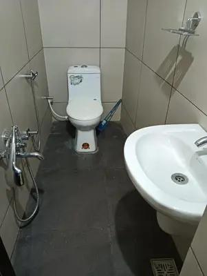 a bathroom with a toilet and a sink at Aloravillasbooking in Wayanad