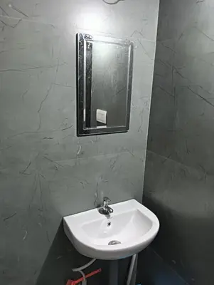 a bathroom with a sink and a mirror on the wall at Aloravillasbooking in Wayanad
