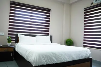 a bedroom with a large bed and a large window at Eagle Nest Residency in Perintalmanna