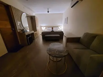 a living room with a couch and a bed at Aurora The Pool Villa in Kozhikode