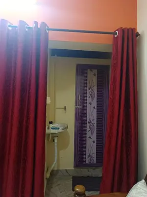 a bathroom with a shower curtain and a sink at Holy Family Nest in Mysore